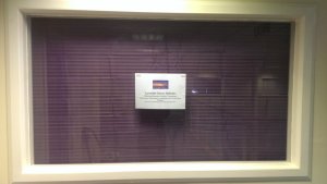 With a wooden blind and purple voile